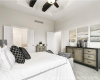 Bedroom featuring light colored carpet, ceiling fan, and a towering ceiling