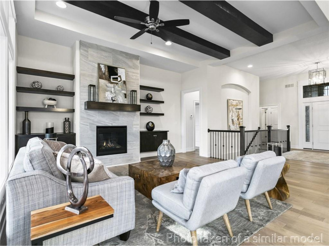 Living room featuring recessed lighting, wood finished floors, a ceiling fan, a premium fireplace, and beamed ceiling