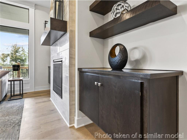 Detailed view of a tiled fireplace and wood finished floors