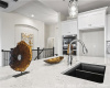 Kitchen with light stone countertops, recessed lighting, white cabinetry, a chandelier, and pendant lighting